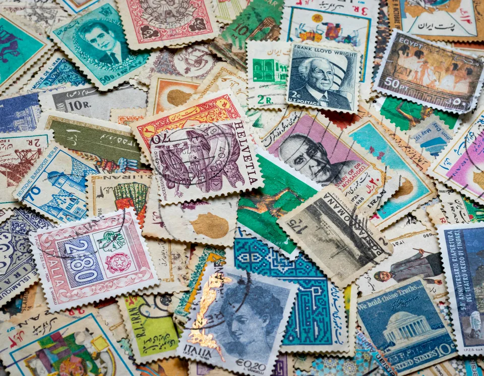 assorted postage stamps on blue and white textile