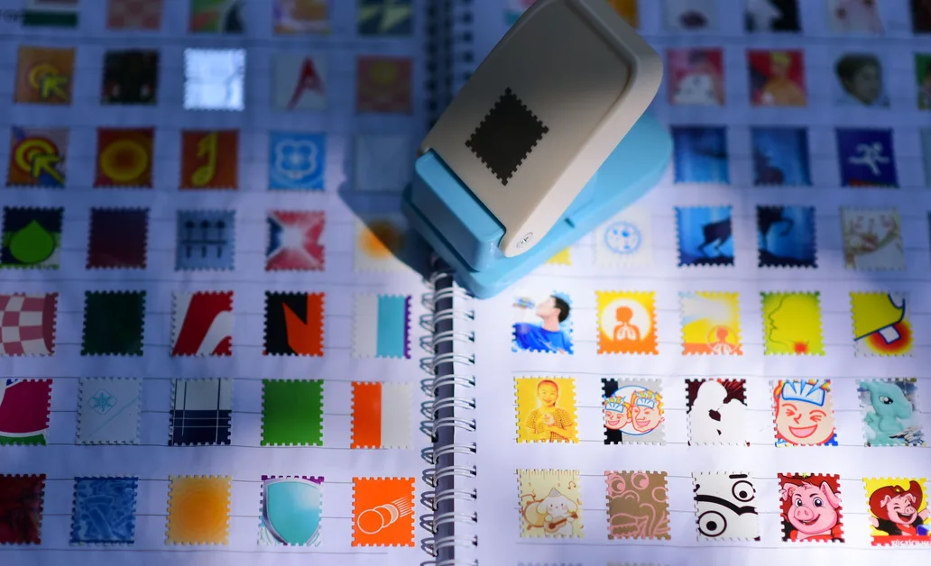 A vibrant display of a stamp collection with a blue stamp punch in focus, casting shadows.